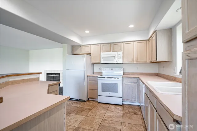 a kitchen with a sink a refrigerator and a stove top oven