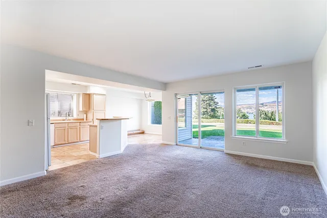 a view of a kitchen with refrigerator and windows