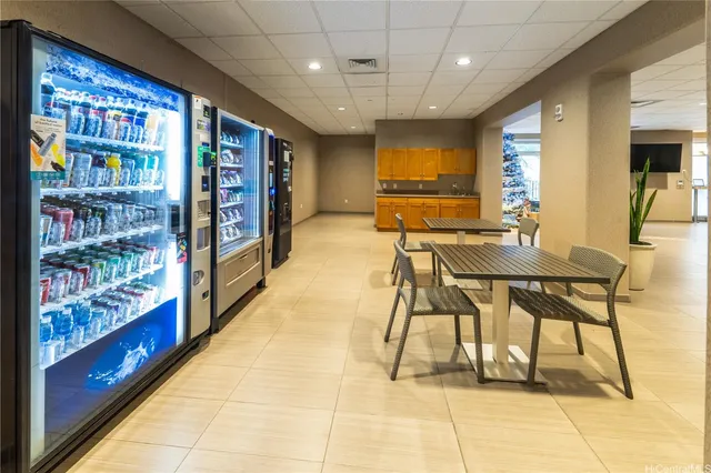 a dining hall with stainless steel appliances granite countertop a rug and white cabinets