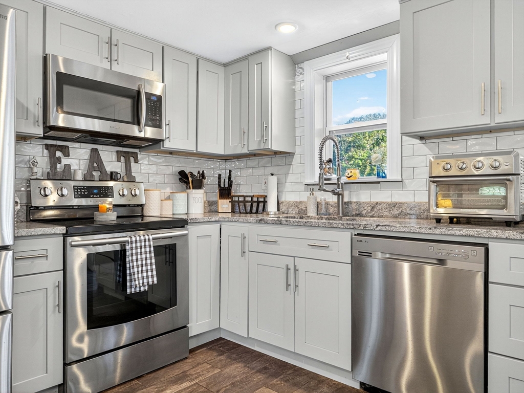 31 Tingley Road Braintree, MA 02184 - Photo 9 of 30 a kitchen with granite countertop a stove top oven microwave and cabinets