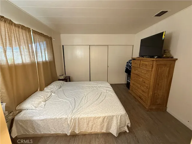 a bedroom with a bed and flat screen tv