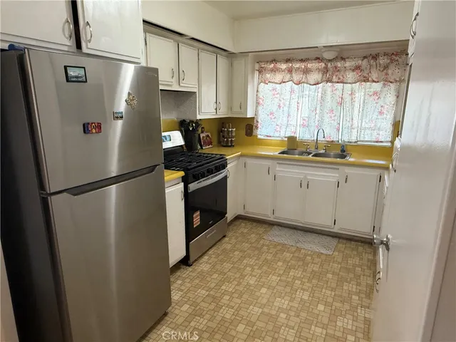 a kitchen with granite countertop a refrigerator and a sink