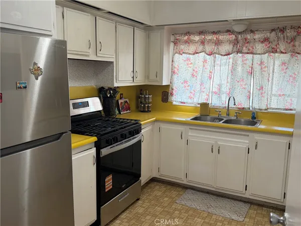 a kitchen with stainless steel appliances granite countertop a refrigerator a sink and a stove