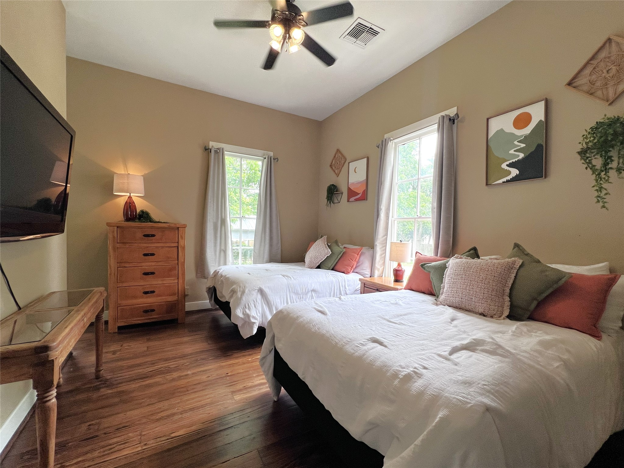 606 Sycamore Street Brenham, TX 77833 - Photo 16 of 27 a bedroom with a bed and wooden floor