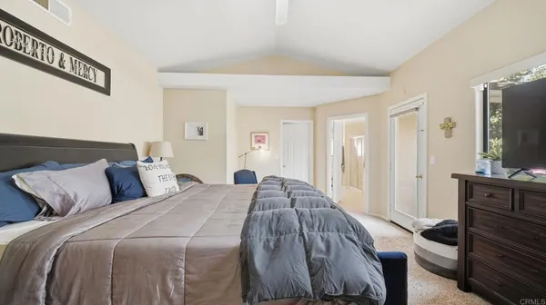 a bed sitting in a bedroom and view of living room
