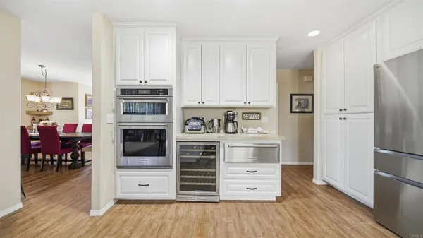 a kitchen with stainless steel appliances wooden floor and a refrigerator