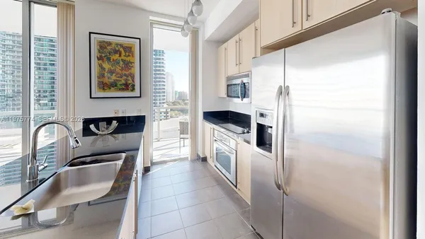 a kitchen with stainless steel appliances granite countertop a refrigerator and a sink