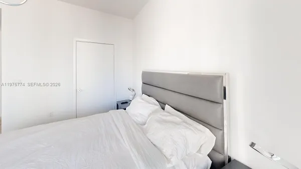 a bedroom with a bed and a night stand