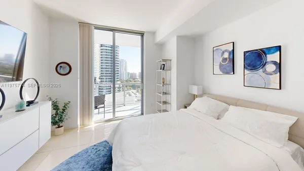 a bedroom with a large bed and a window