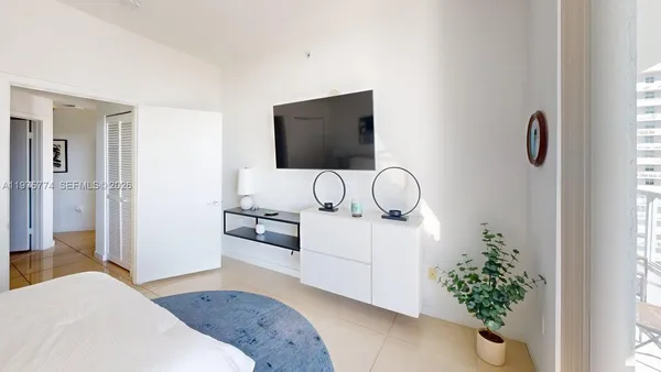 a bedroom with a bed and a potted plant
