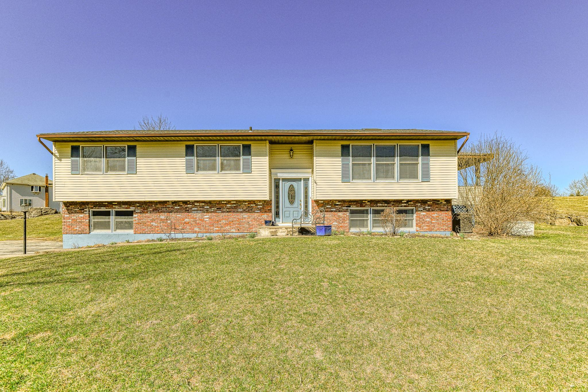 Bi-level home featuring brick siding and a front yard