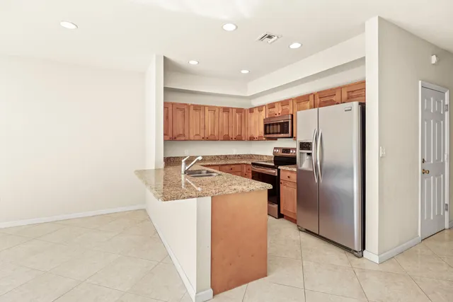 a kitchen with stainless steel appliances granite countertop a refrigerator and a stove