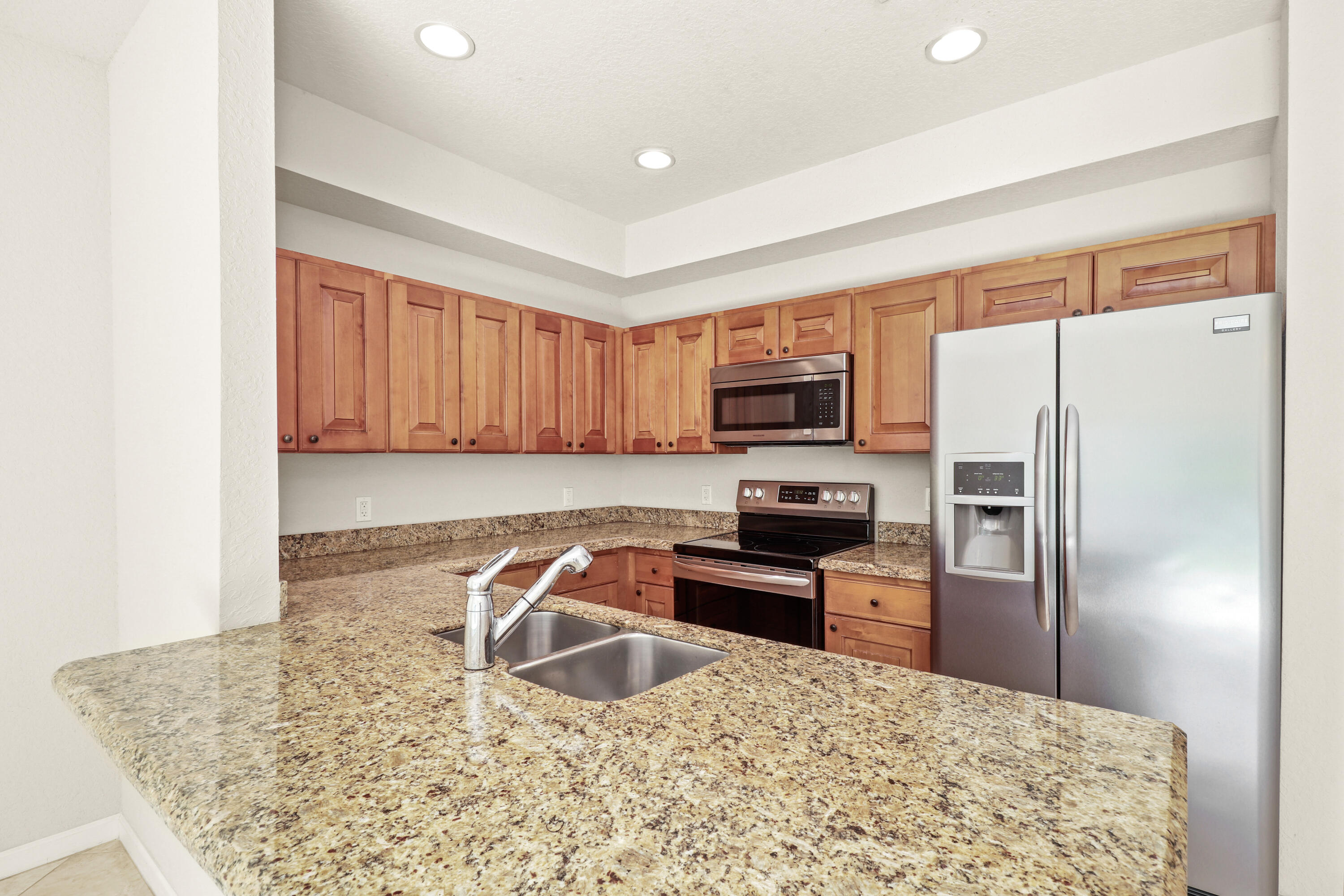 37 Southeast 3rd Avenue Hallandale Beach, FL 33009 - Photo 15 of 47 a kitchen with stainless steel appliances granite countertop a refrigerator a stove a sink a microwave oven with white cabinets