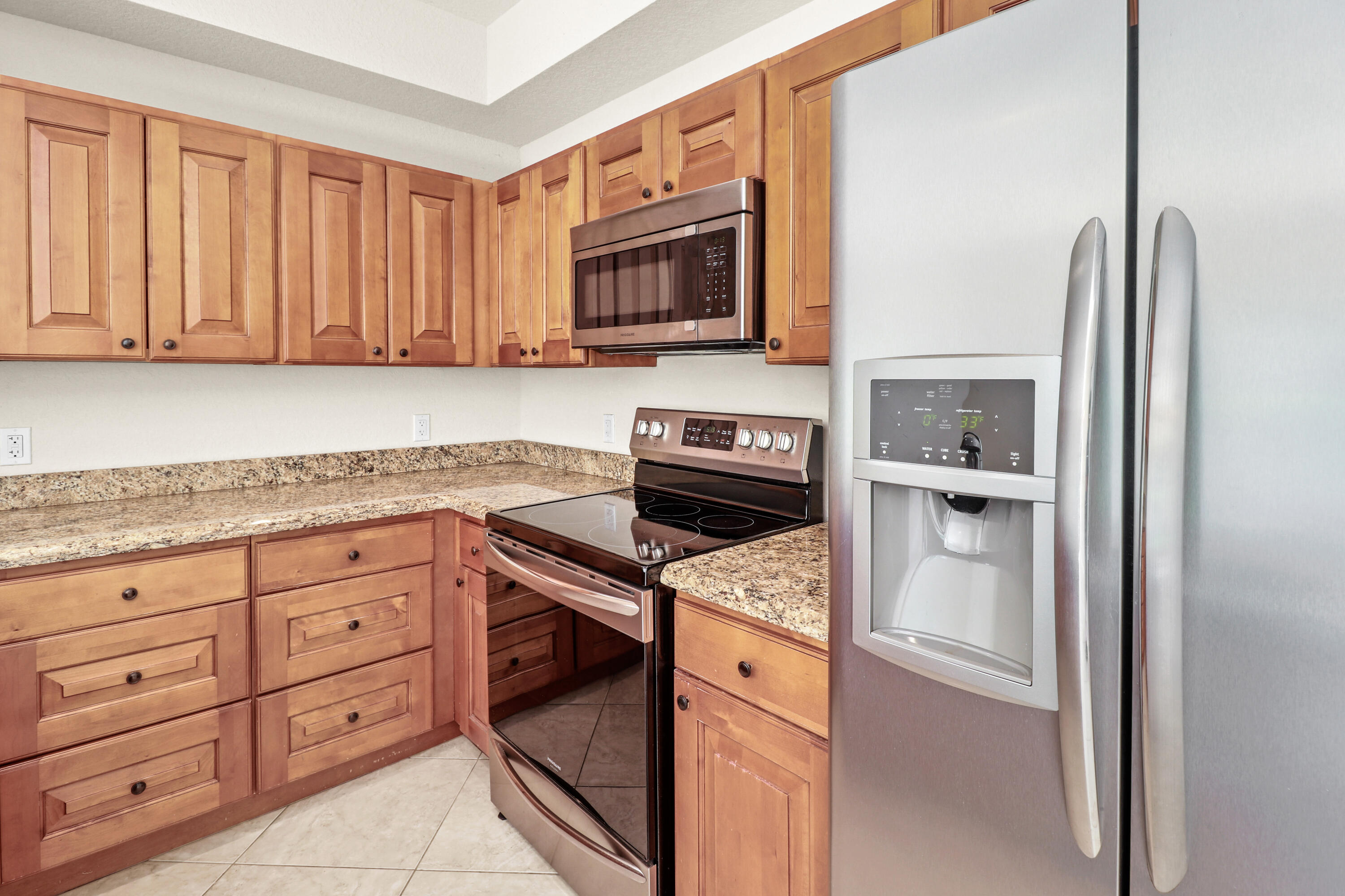 37 Southeast 3rd Avenue Hallandale Beach, FL 33009 - Photo 19 of 47 a kitchen with granite countertop a refrigerator stove and microwave