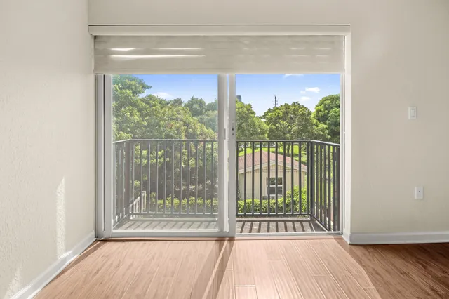 a view of a room with wooden floor and a floor to ceiling window