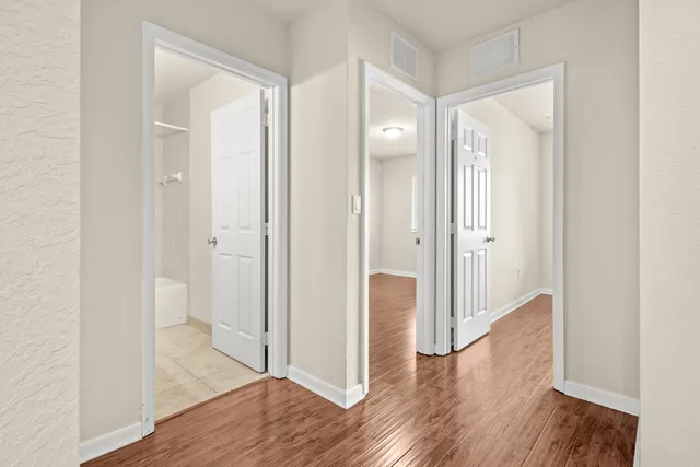 a view of a hallway with wooden floor