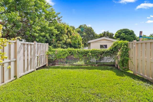 a view of house with backyard and a garden