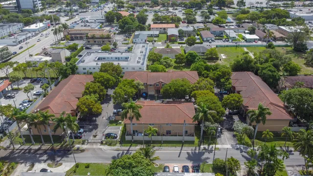 an aerial view of residential houses with outdoor space and trees