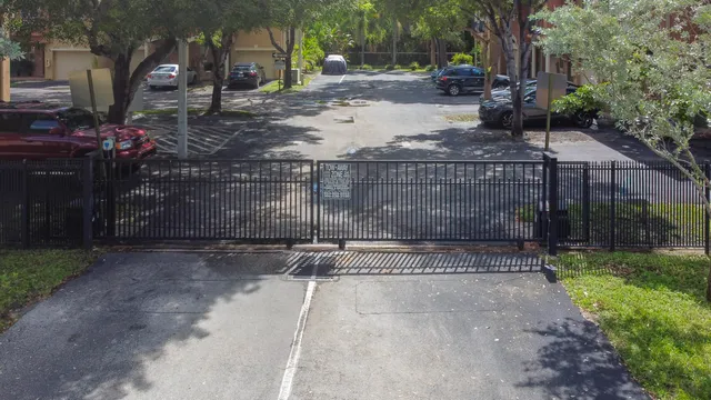 a view of a street with a small yard and large trees