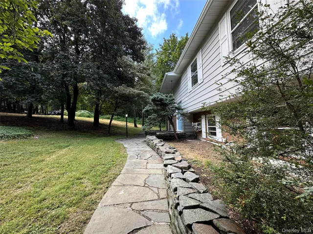 a view of a yard with plants and trees