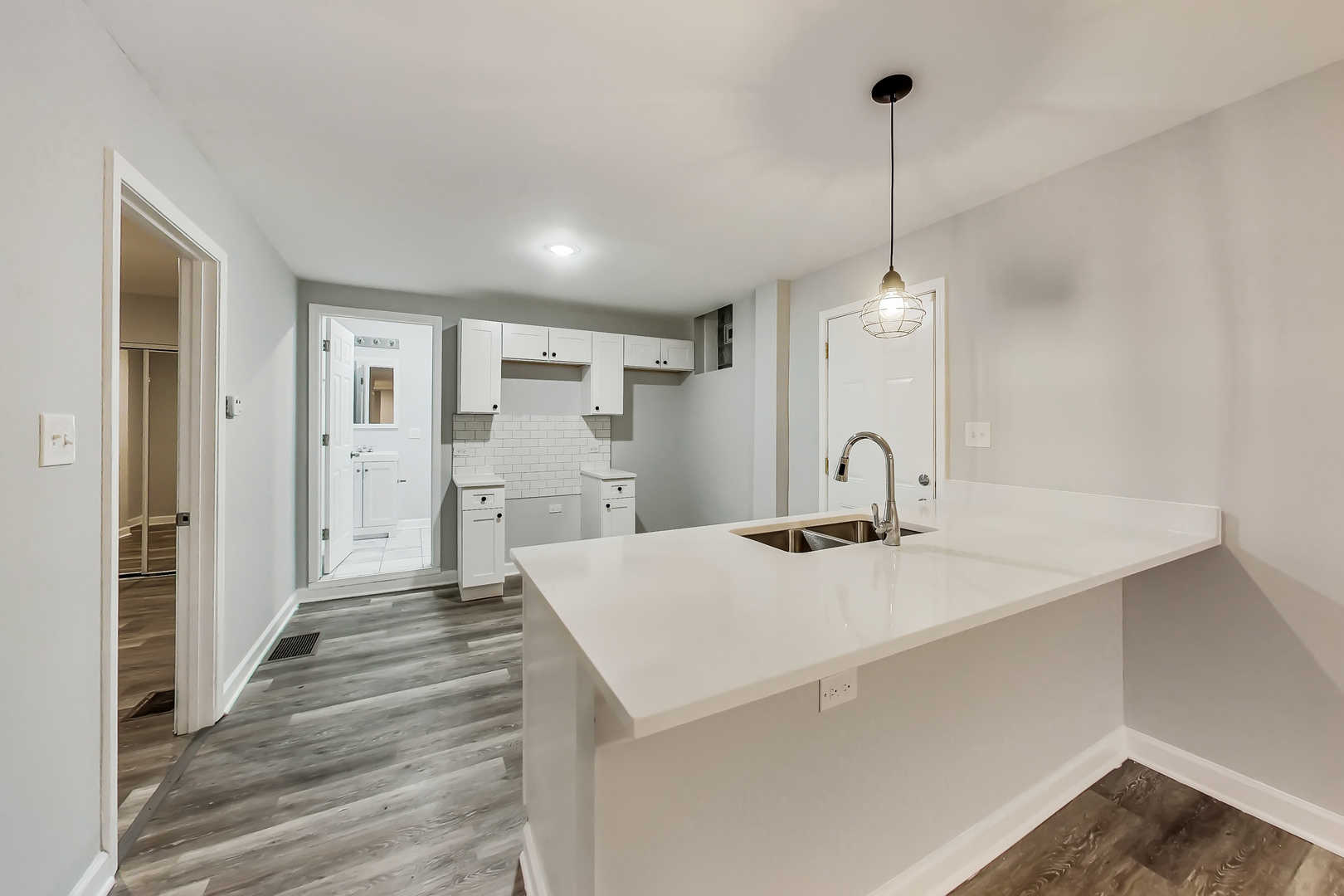 2338 West 18th Place Chicago, IL 60608 - Photo 7 of 63 a view of a kitchen island a sink wooden floor and a living room