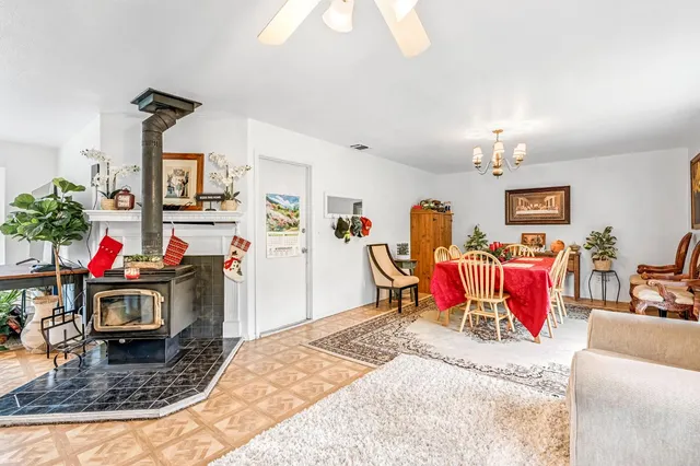 a living room with furniture kitchen view and a chandelier