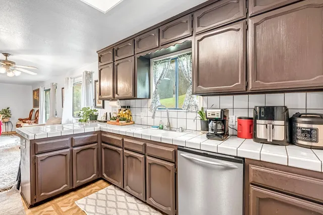 a kitchen with stainless steel appliances granite countertop a sink a stove and cabinets