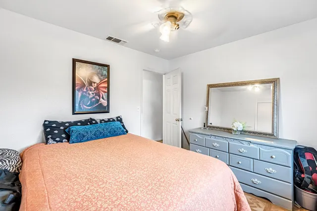 a bedroom with a large bed and a mirror on dresser