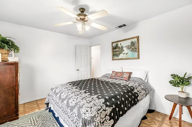 a bedroom with a large bed and a chandelier