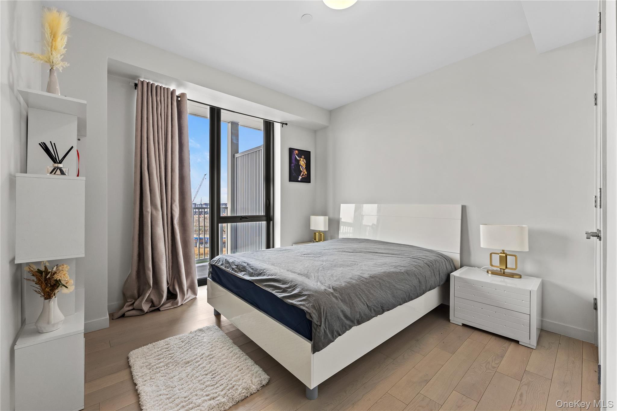 131-02 40th Road, Unit 9H Queens, NY 11354 - Photo 11 of 25 a bed room with a bed and a couch