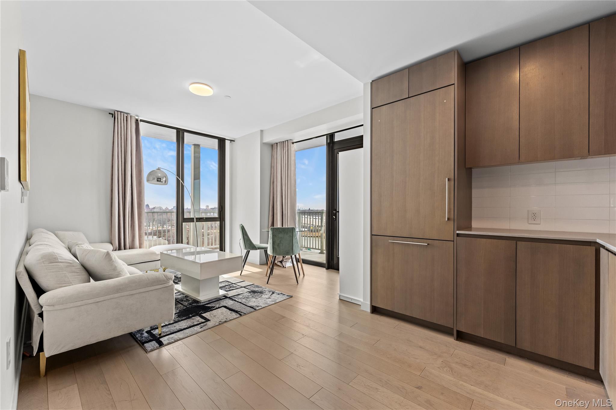 131-02 40th Road, Unit 9H Queens, NY 11354 - Photo 2 of 25 a living room with furniture and a large window