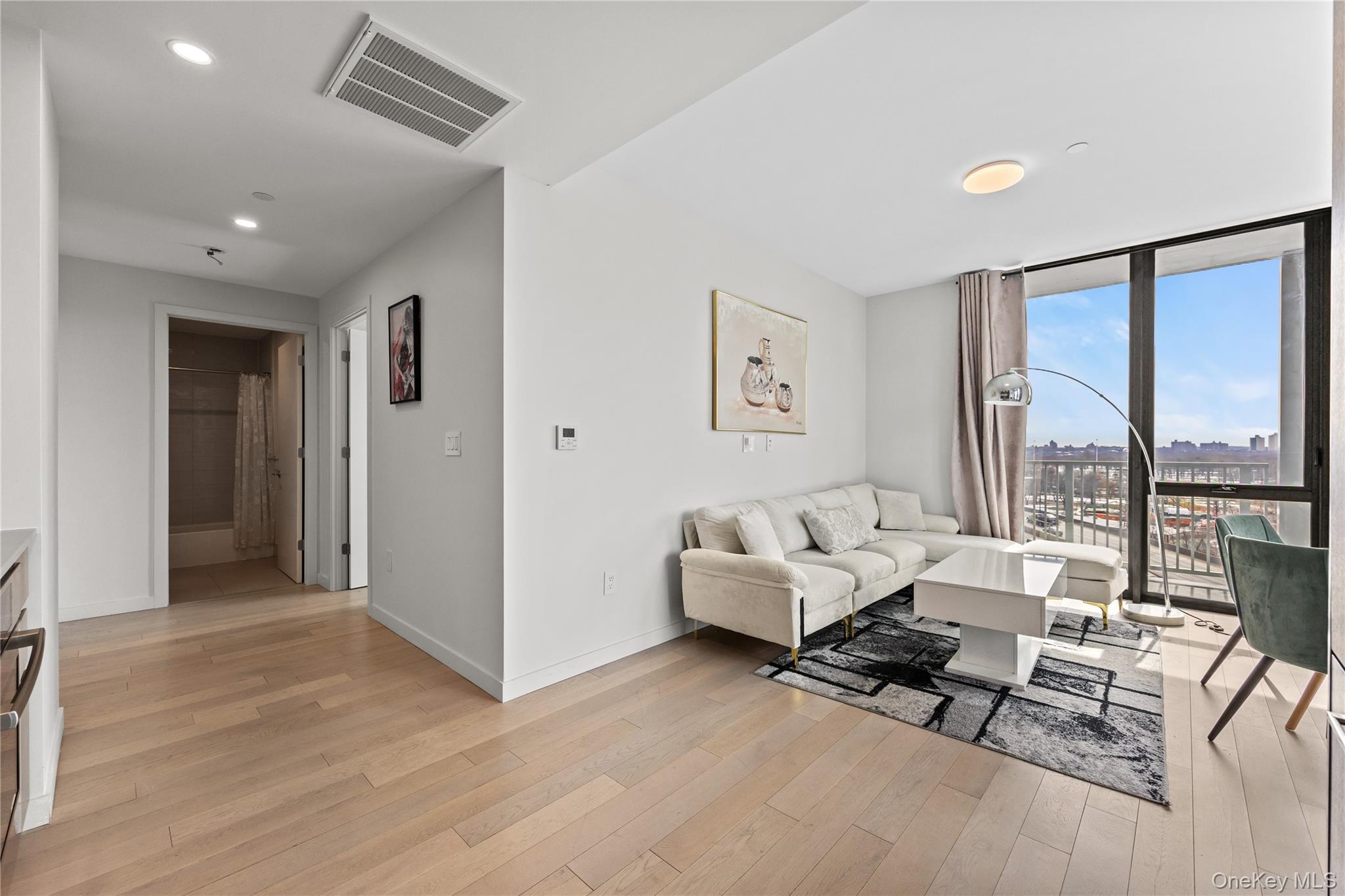 131-02 40th Road, Unit 9H Queens, NY 11354 - Photo 3 of 25 a living room with furniture and large windows
