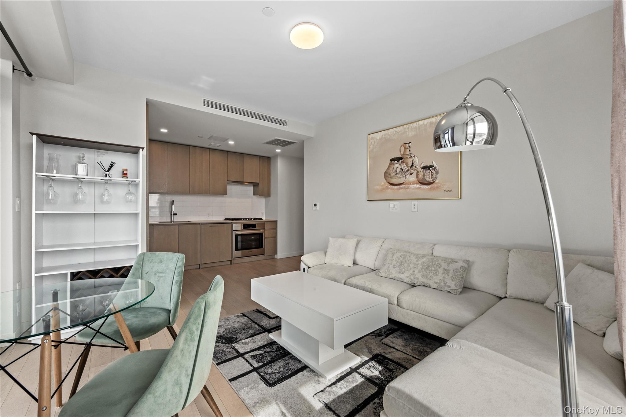 131-02 40th Road, Unit 9H Queens, NY 11354 - Photo 4 of 25 a living room with furniture and a chandelier