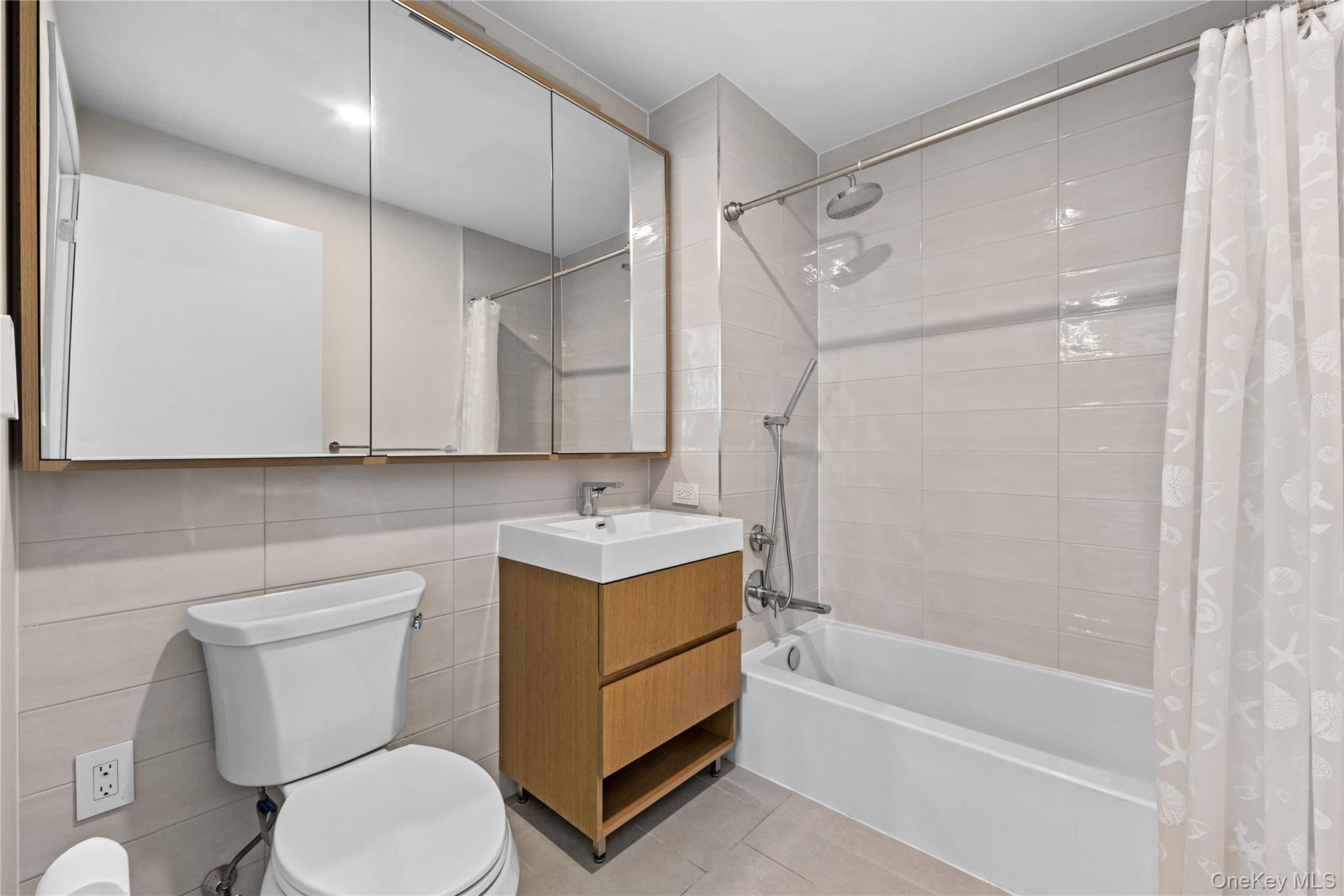131-02 40th Road, Unit 9H Queens, NY 11354 - Photo 9 of 25 a bathroom with a sink a toilet and shower