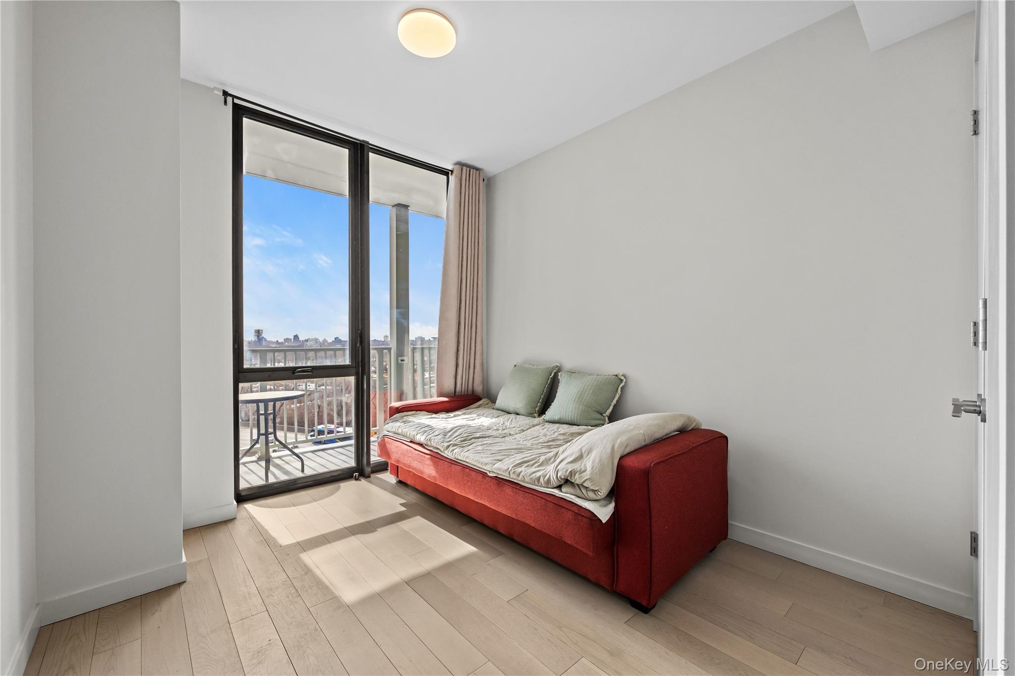 131-02 40th Road, Unit 9H Queens, NY 11354 - Photo 10 of 25 a bedroom with a bed and window