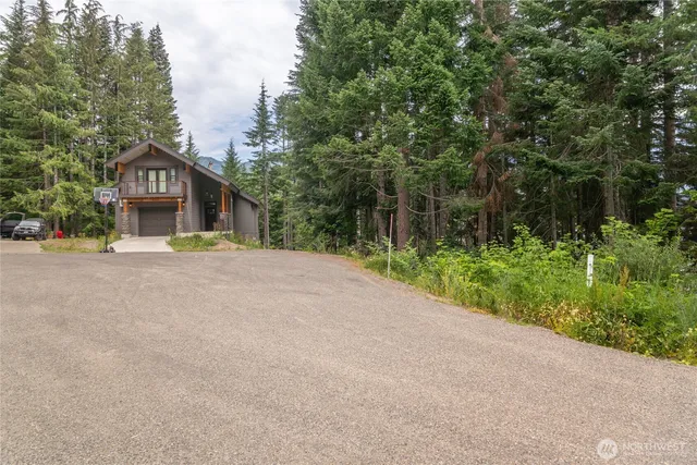 a view of a house with a yard and large trees
