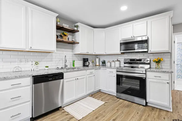 a kitchen with stainless steel appliances granite countertop a stove sink microwave and cabinets