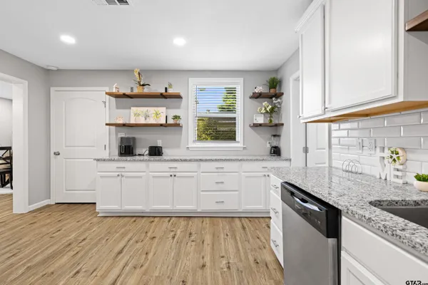 a kitchen with stainless steel appliances granite countertop a sink stove and cabinets