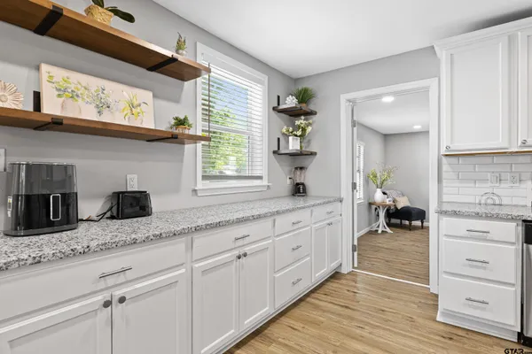 a kitchen with granite countertop cabinets stainless steel appliances a sink and a window