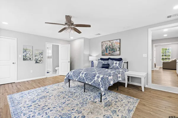 a bedroom with a bed and wooden floor