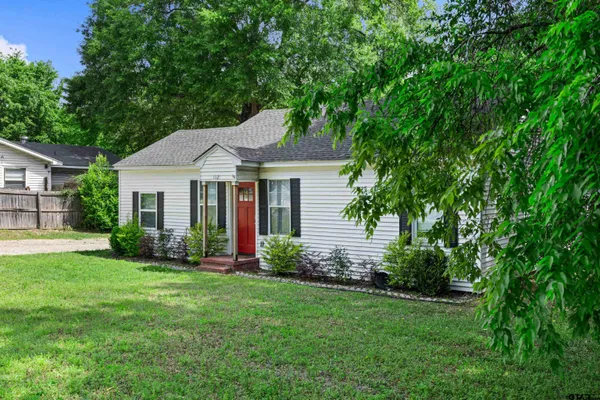 a front view of a house with a garden and yard