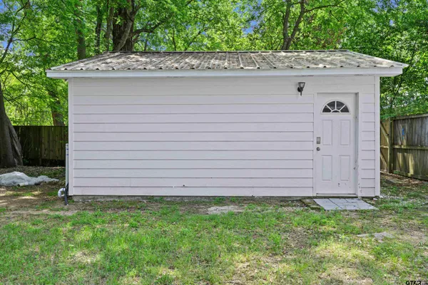 a view of a house with a wooden fence