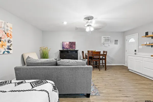 a living room with furniture and a wooden floor
