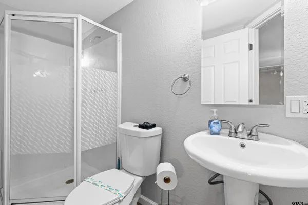 a bathroom with a toilet a sink and mirror