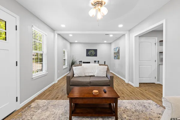 a living room with furniture a rug and kitchen view