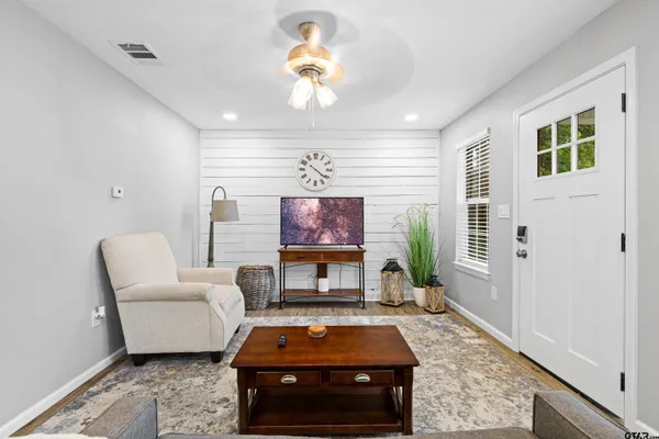 a living room with furniture a fireplace and a flat screen tv