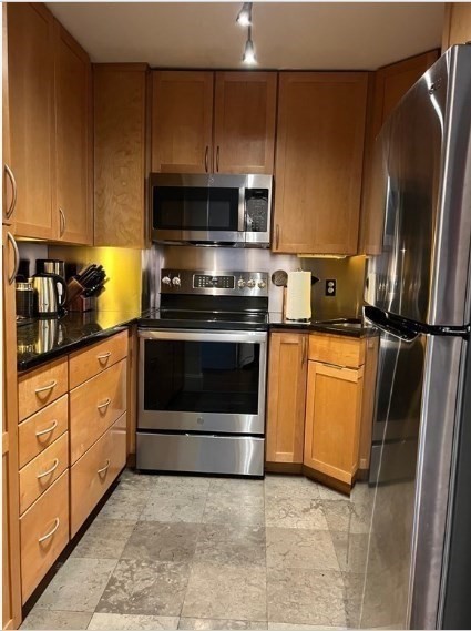 416 Marlborough Street, Unit 501 Boston, MA 02115 - Photo 7 of 12 a kitchen with stainless steel appliances granite countertop a stove a refrigerator and a microwave