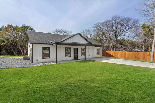 a front view of a house with a yard and trees