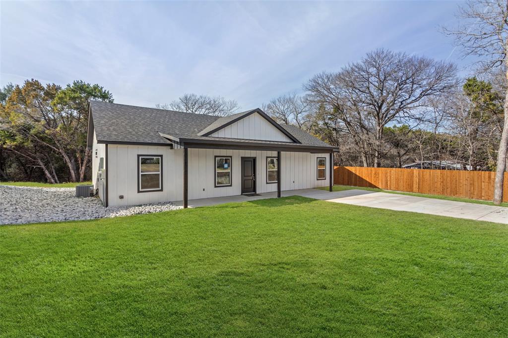 a front view of a house with a yard and trees