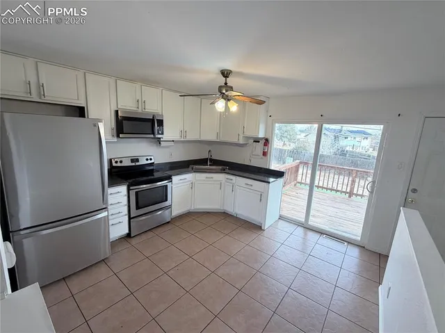 a kitchen with white cabinets stainless steel appliances and a sink